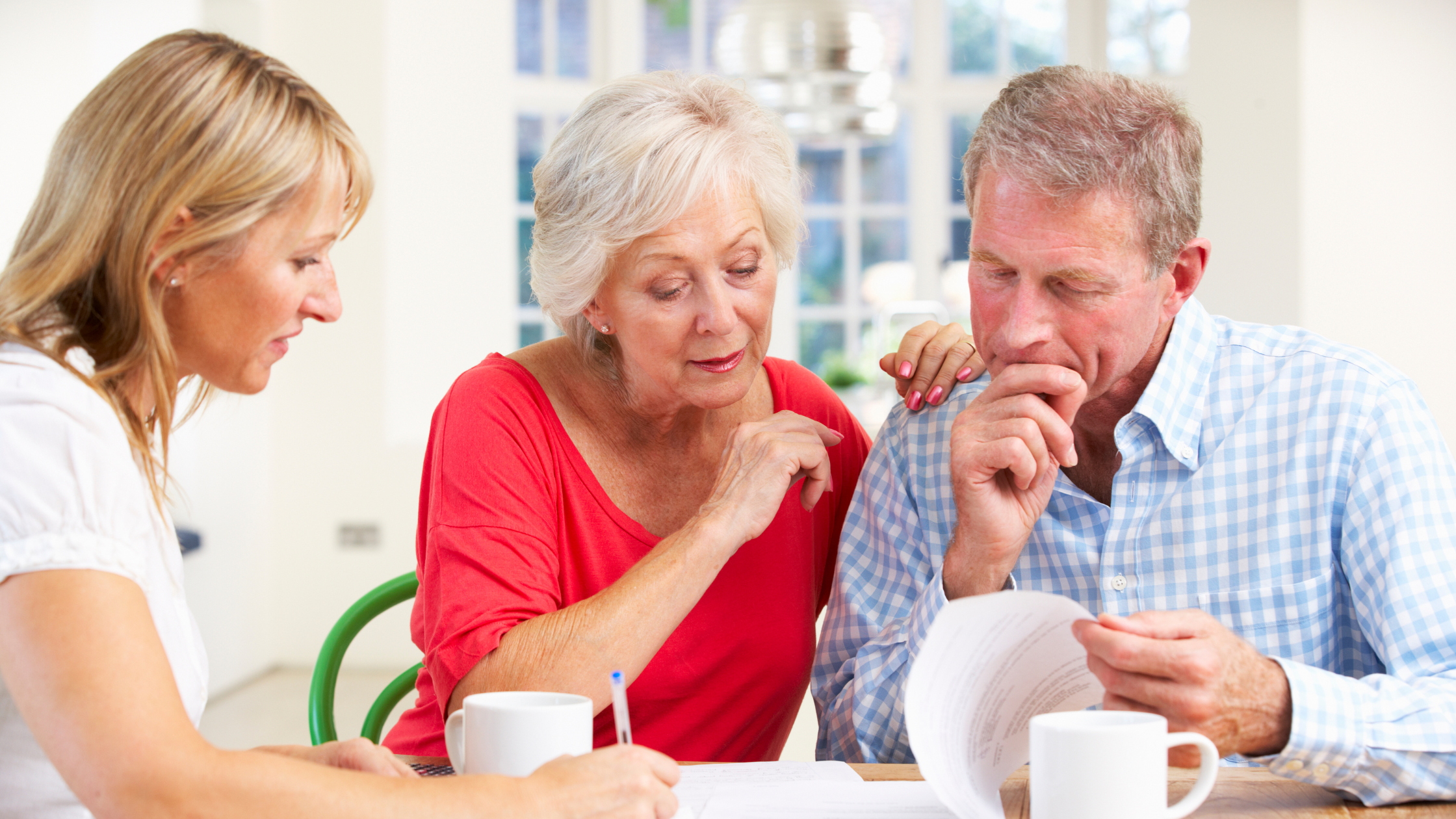 Elderly couple review their will details with the guidance of a trusted advisor.